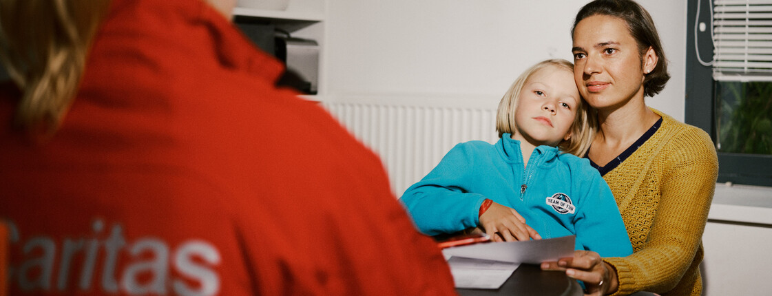 Mutter mit Kind sucht Hilfe bei der Caritas.