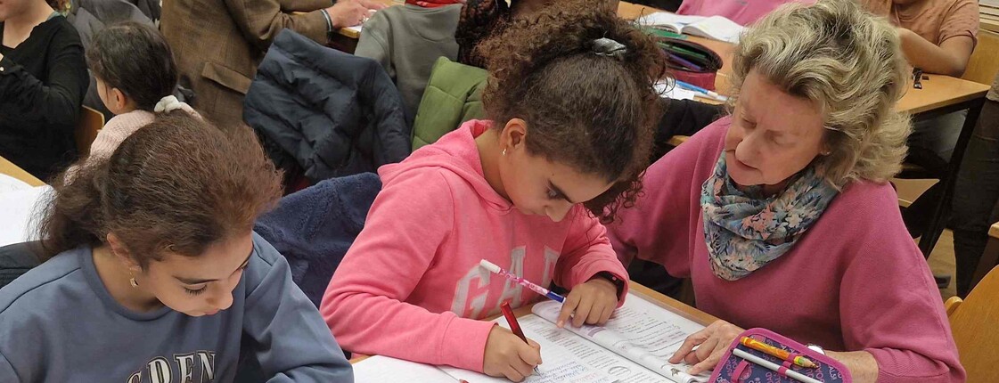 Frau lernt mit zwei Mädchen am Tisch