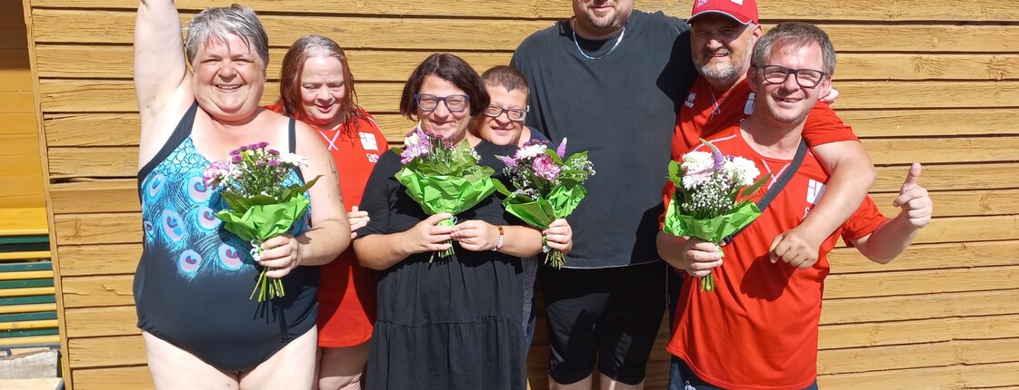 Menschen mit Behinderung mit Blumenstrauß freuen sich