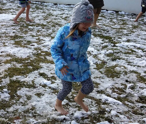 Kinder aus dem Caritas Kindergarten Unterfrauenhaid laufen barfuß im Schnee zum Kneippen.