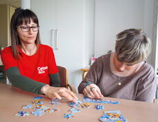Eine Bewohnerin und eine Betreuerin lösen gemeinsam ein Puzzle.