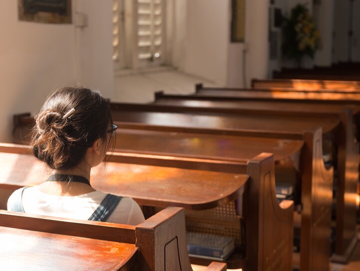 Junge Frau sitzt in der Kirche