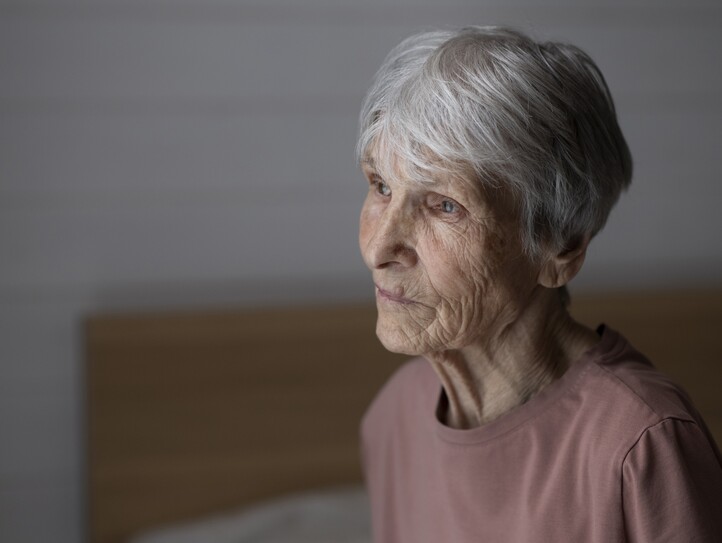 Eine Pensionistin blickt nachdenklich zur Seite.