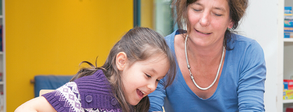 Mädchen und freiwillige Mitarbeiterin im Lerncafé