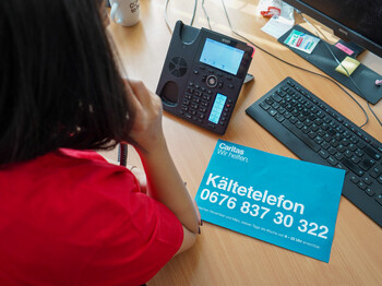 Eine Caritas Mitarbeiterin telefoniert im Kältetelefon Büro.