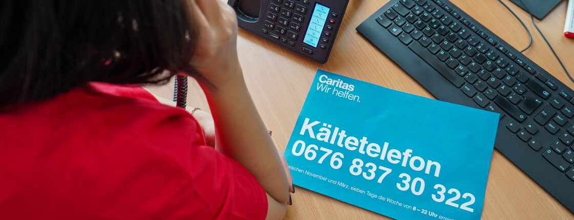 Eine Caritas Mitarbeiterin telefoniert im Kältetelefon Büro.