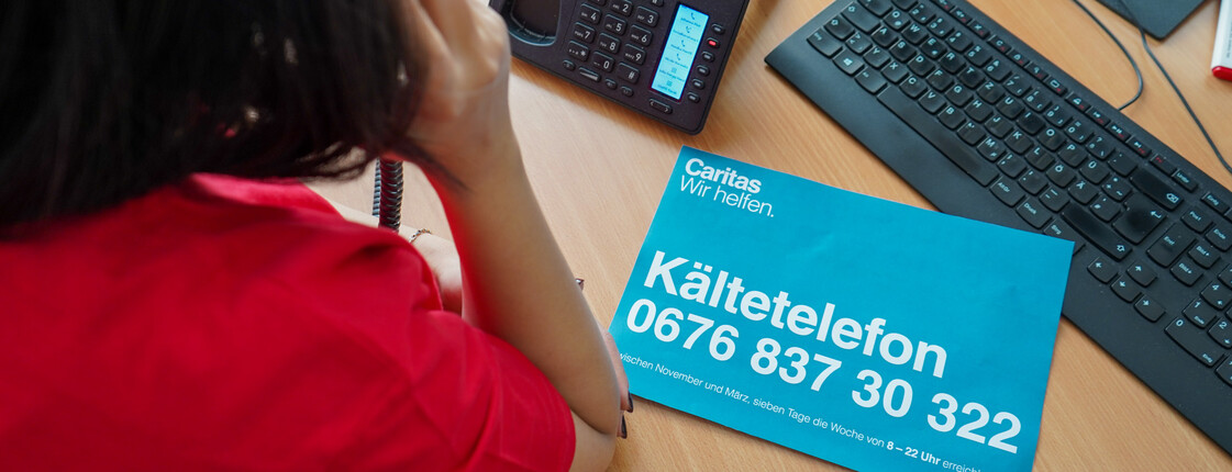Eine Caritas Mitarbeiterin telefoniert im Kältetelefon Büro.