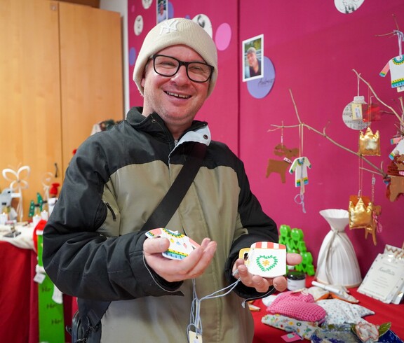 Ein Bewohner hält Dekoration in den Händen.