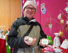 Ein Bewohner hält Dekoration in den Händen.