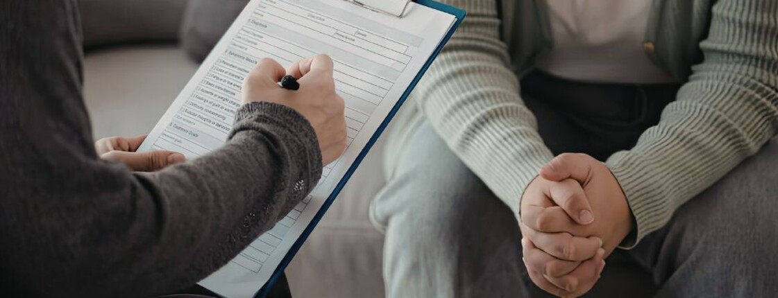 Eine Person füllt Formulare für eine andere aus.