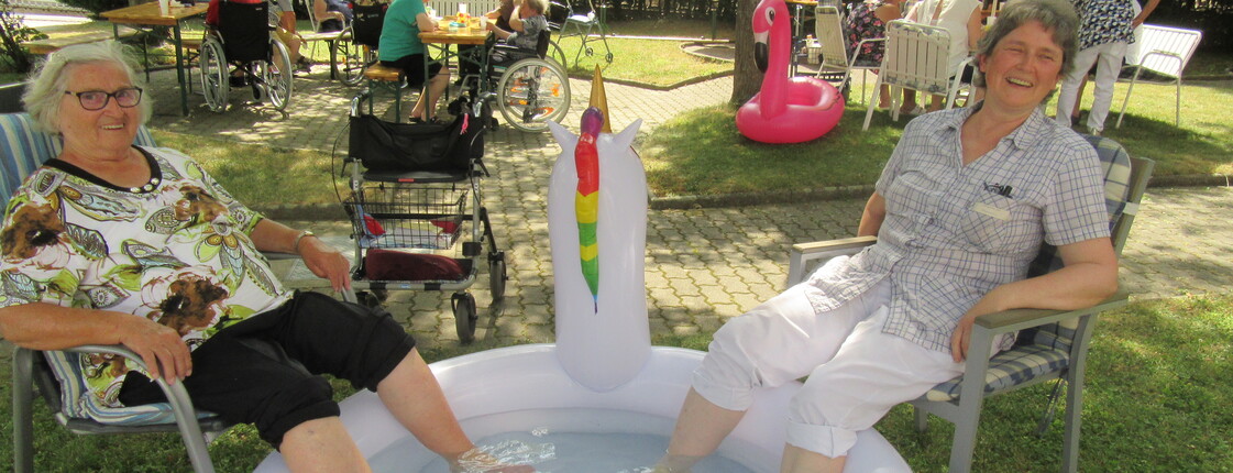 Zwei Bewohnerinnen genießen eine Abkühlung mit Füßen im Mini-Pool. (Caritas Haus Elisabeth)