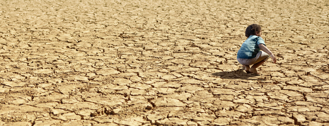 Kampf gegen den Hunger Child Playing on Dry Parched Desert Land