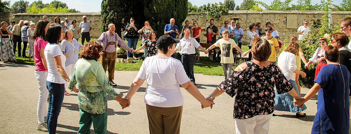 Bewohner*innen vom Caritas Haus Vitus tanzen gemeinsam beim Sommerfest