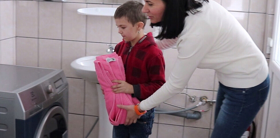 Cristina und ihre Betreuerin beim Waschen im Waschraum des Caritas Kinderzentrums in Cenade Rumänien